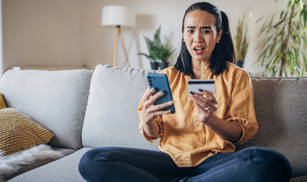 Pet sitters targeted by scammers A pet sitter sits with an upset, shocked expression on her face looking at her credit card and cellphone.